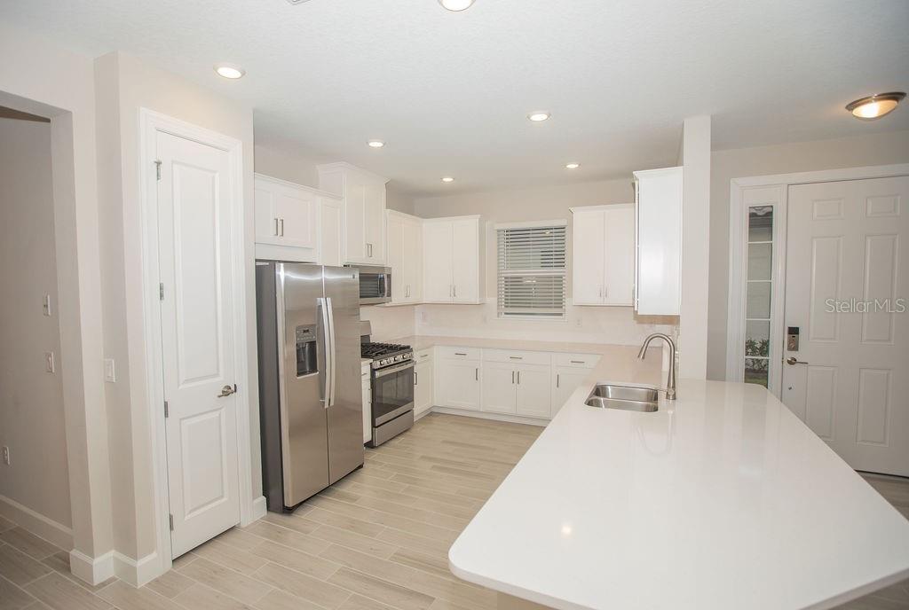 4605 Rosatti Road Wesley Chapel, FL 33543 - Photo 10 of 26 a large white kitchen with lots of counter space wooden floor and appliances