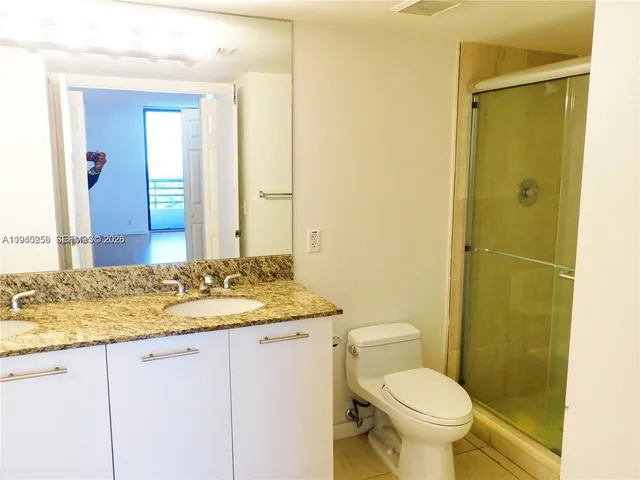 a bathroom with a granite countertop sink toilet and shower