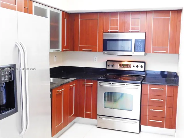 a kitchen with stainless steel appliances granite countertop a stove and a microwave