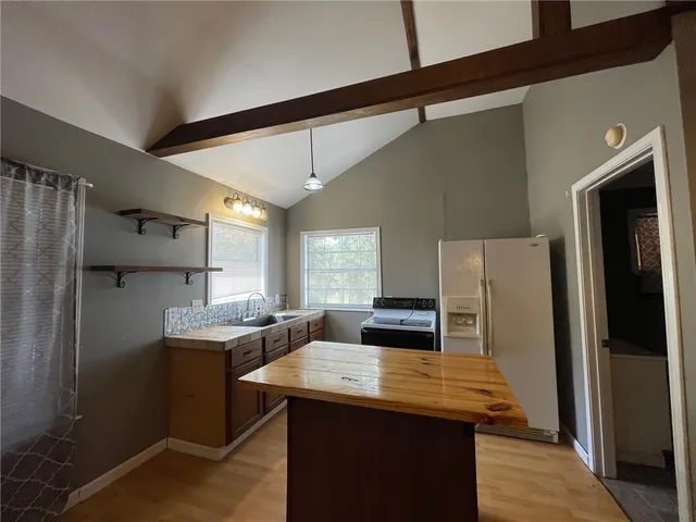 a kitchen with stainless steel appliances kitchen island a refrigerator sink and stove