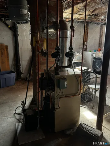 a room with water heater and wooden cabinets