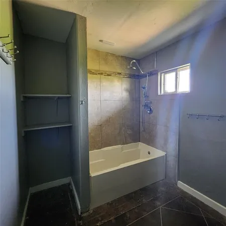 a bathroom with a bathtub and shower