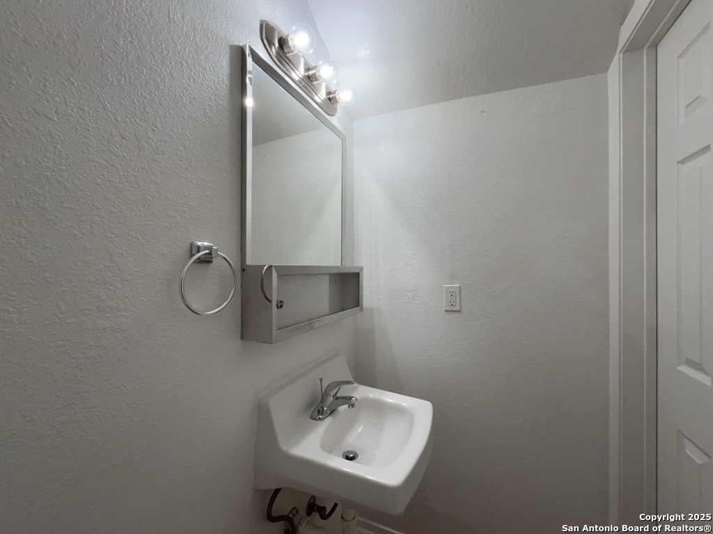 2802 Lasses Boulevard, Unit 42 San Antonio, TX 78223 - Photo 14 of 33 a bathroom with a sink and mirror