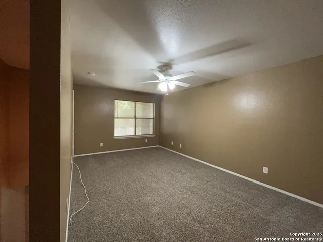 an empty room with closet and fan