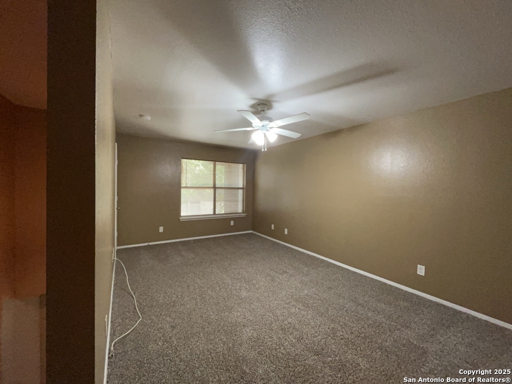 2802 Lasses Boulevard, Unit 42 San Antonio, TX 78223 - Photo 17 of 33 an empty room with windows and chandelier fan