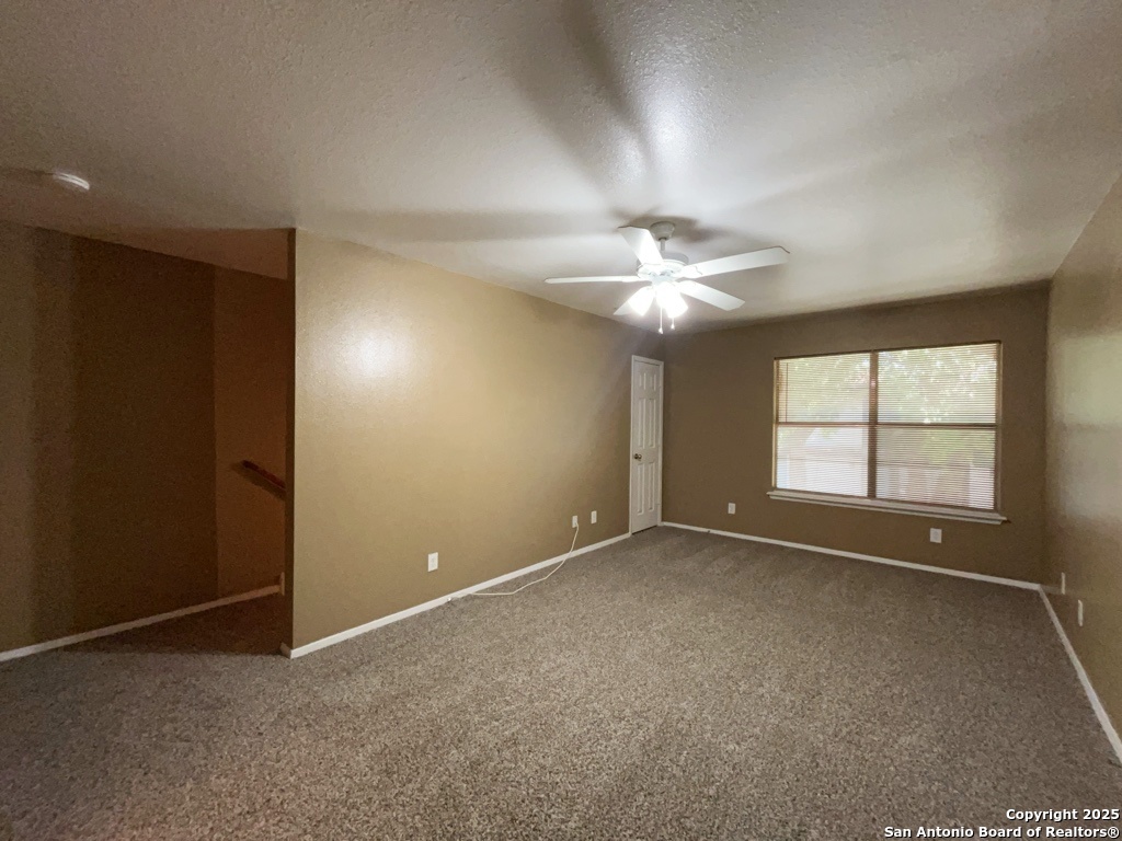 2802 Lasses Boulevard, Unit 42 San Antonio, TX 78223 - Photo 18 of 33 an empty room with chandelier fan and windows