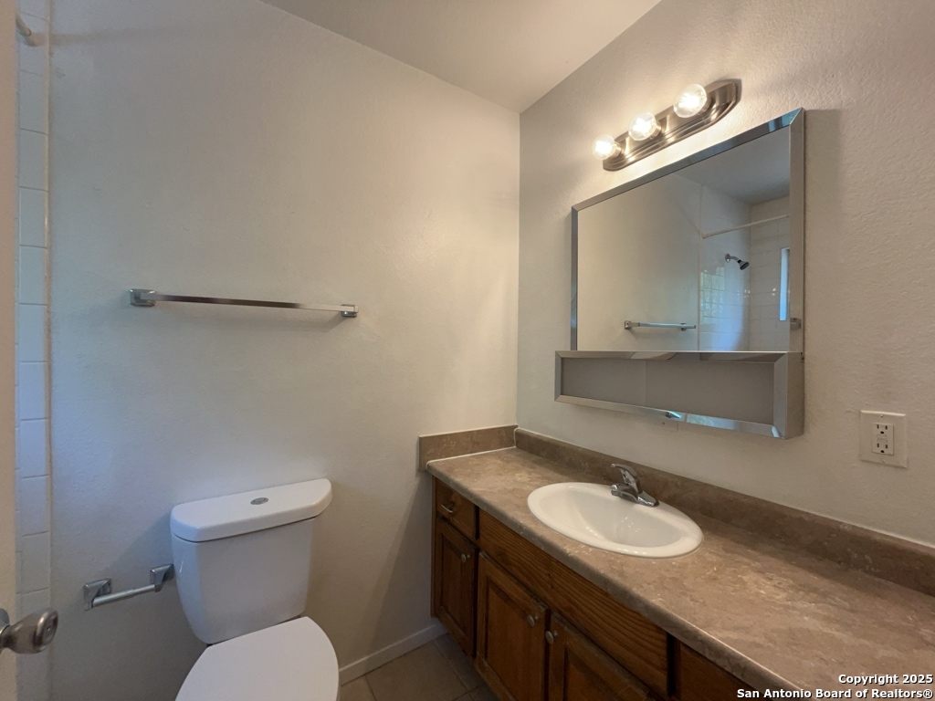 2802 Lasses Boulevard, Unit 42 San Antonio, TX 78223 - Photo 22 of 33 a bathroom with a granite countertop sink toilet and mirror