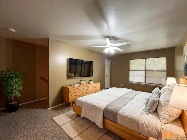 a bedroom with a large bed and a flat screen tv