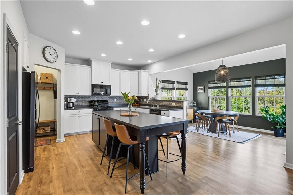 347 Ranchero Drive Coraopolis, PA 15108 - Photo 13 of 46 a kitchen with stainless steel appliances granite countertop a stove refrigerator a dining table and chairs with wooden floor
