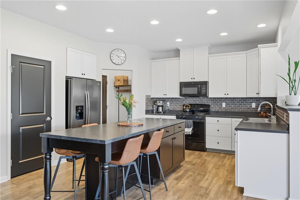 347 Ranchero Drive Coraopolis, PA 15108 - Photo 14 of 46 a kitchen with stainless steel appliances granite countertop a refrigerator a stove top oven a sink dishwasher and white cabinets with wooden floor