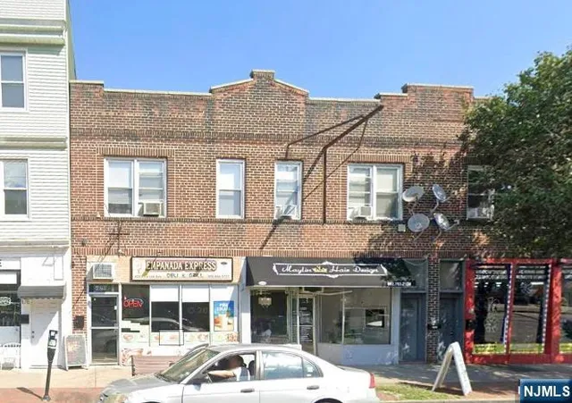 a front view of a building and car parked