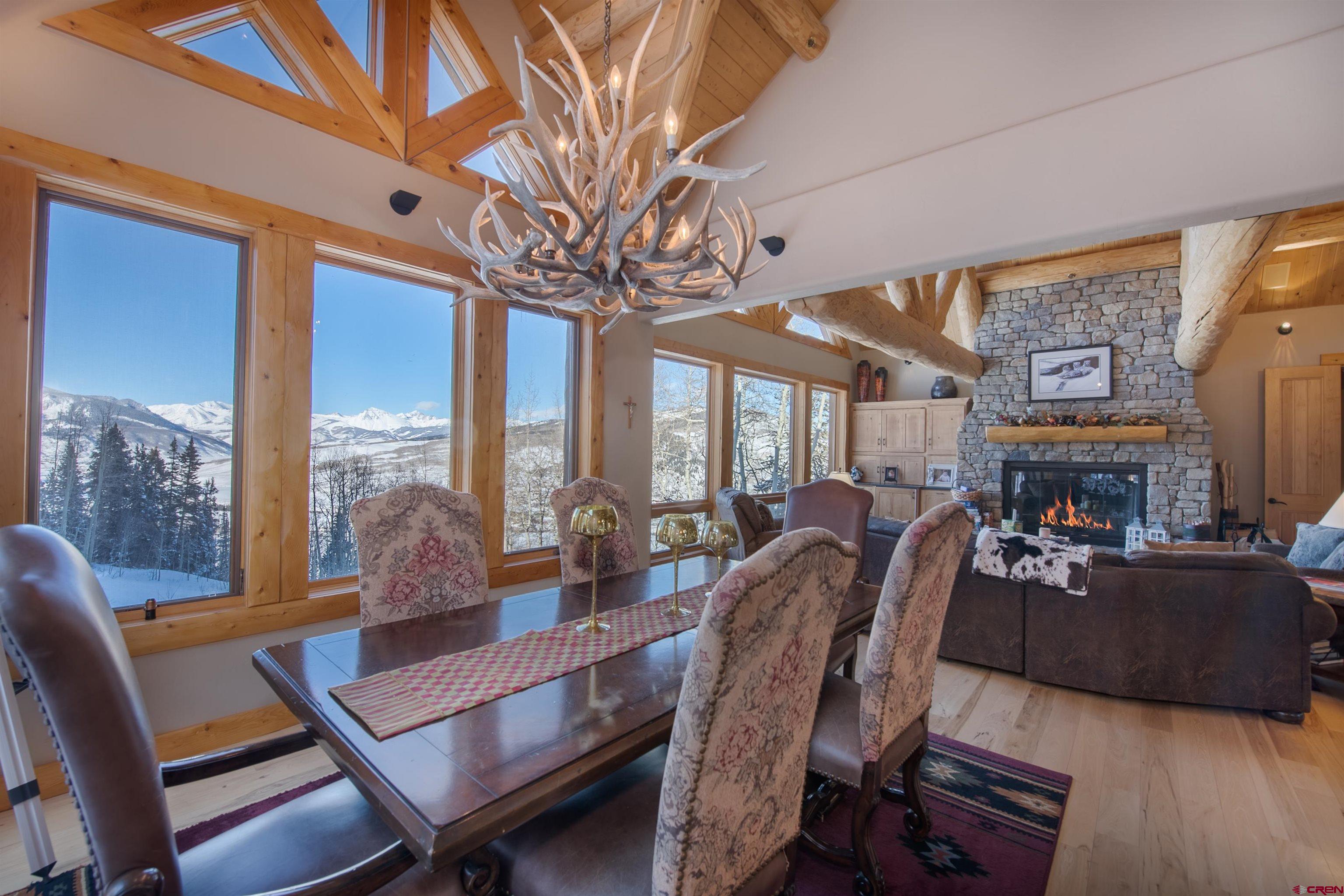 1894 Red Mountain Ranch Road Crested Butte, CO 81224 - Photo 3 of 34 a view of a dining room with furniture a chandelier and large windows