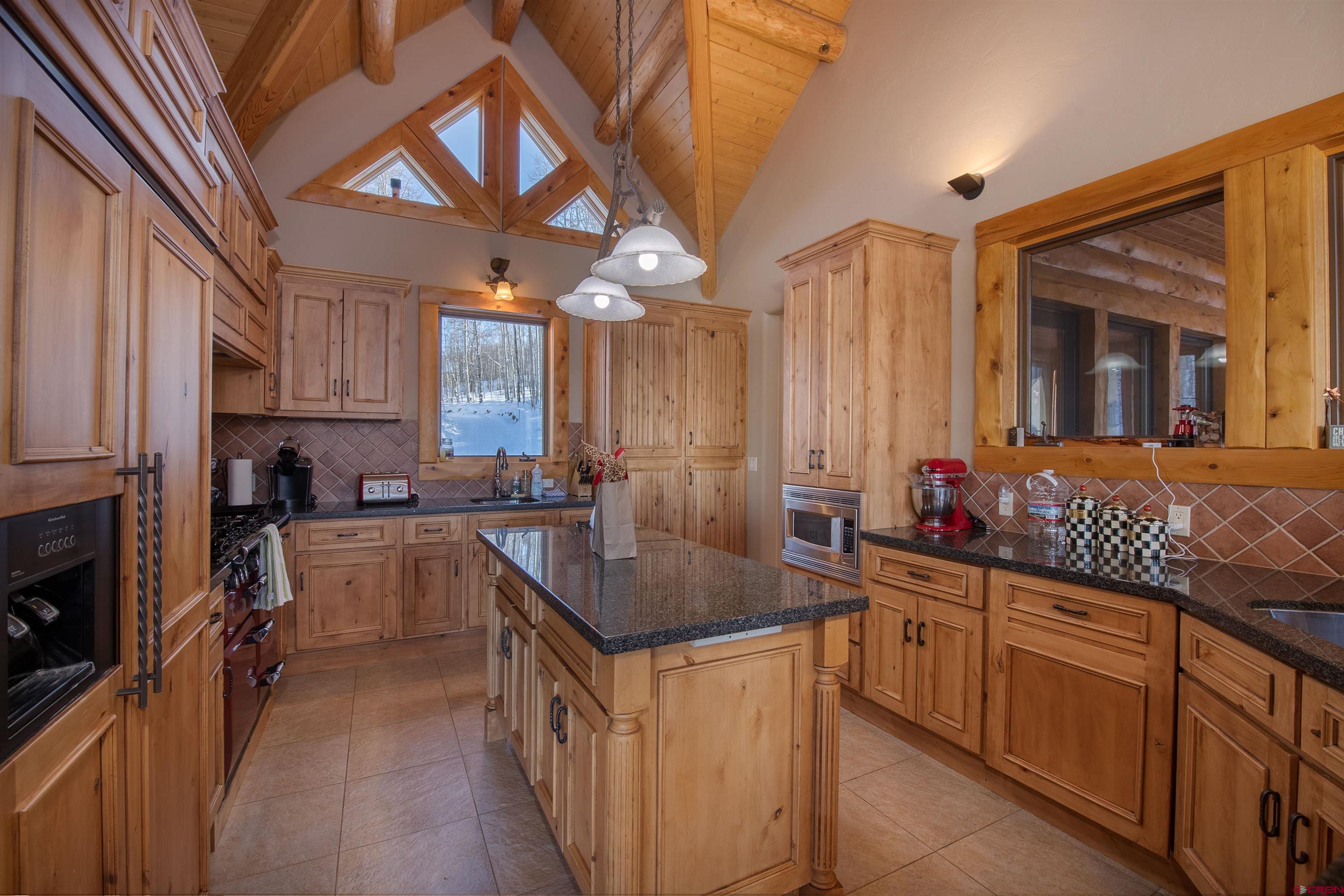 1894 Red Mountain Ranch Road Crested Butte, CO 81224 - Photo 9 of 34 a kitchen with granite countertop a sink stove and cabinets