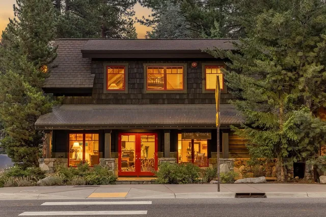 a front view of a house with a tree
