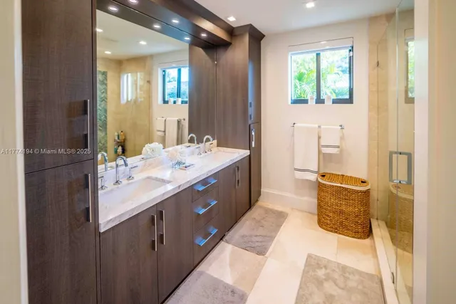 a bathroom with a double vanity sink a mirror and a bathtub