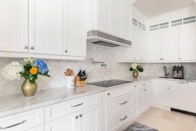 a kitchen with white cabinets and sink