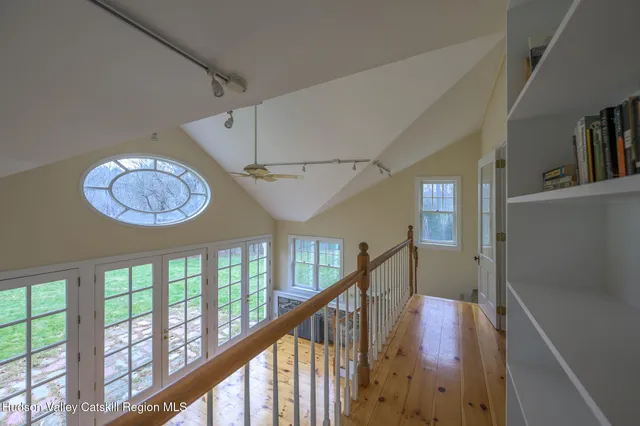 a view of an empty room with wooden floor and a fireplace