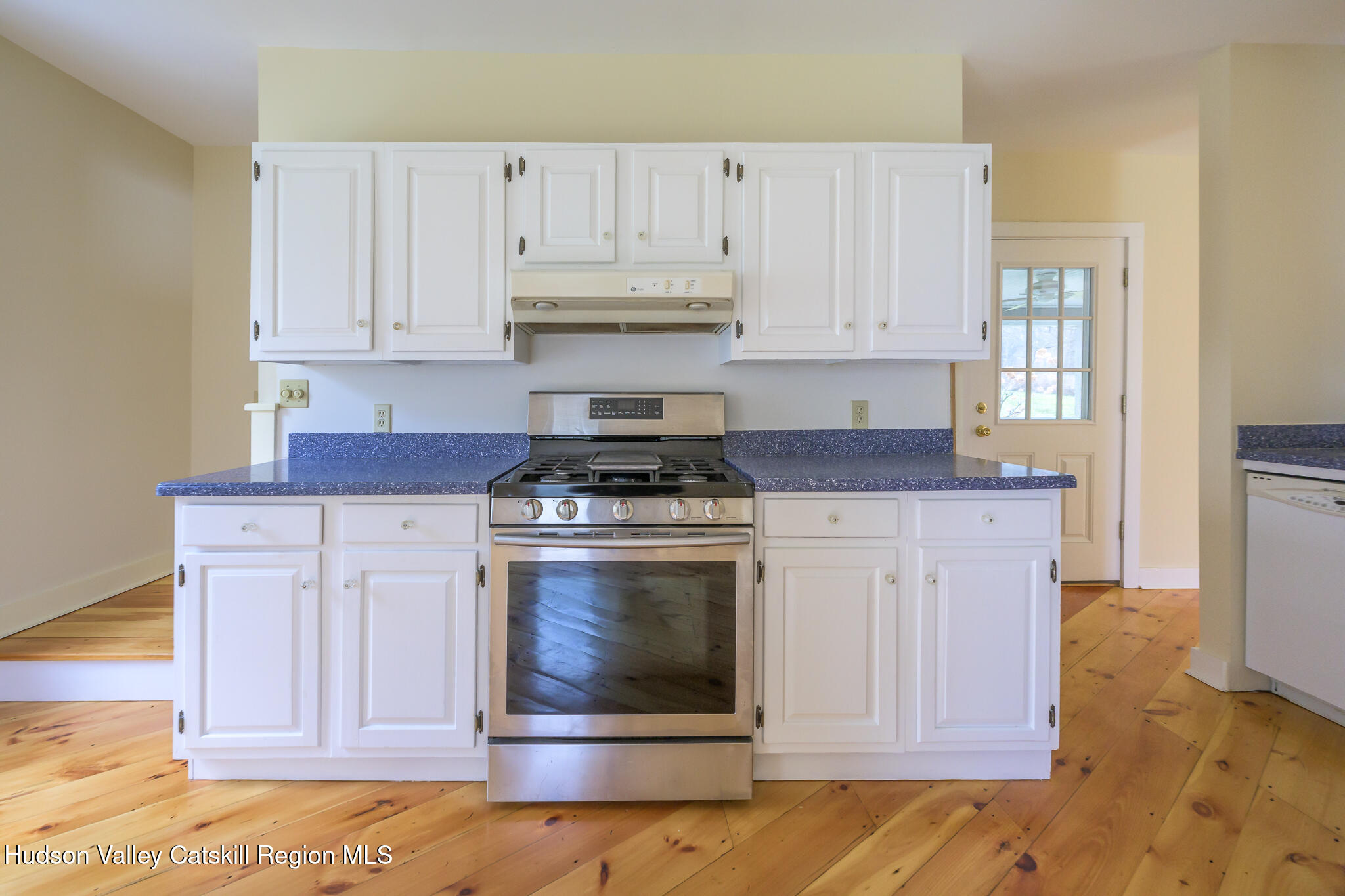 477 Fog Hill Road Austerlitz, NY 12017 - Photo 10 of 33 a kitchen with white cabinets and a stove with wooden floor