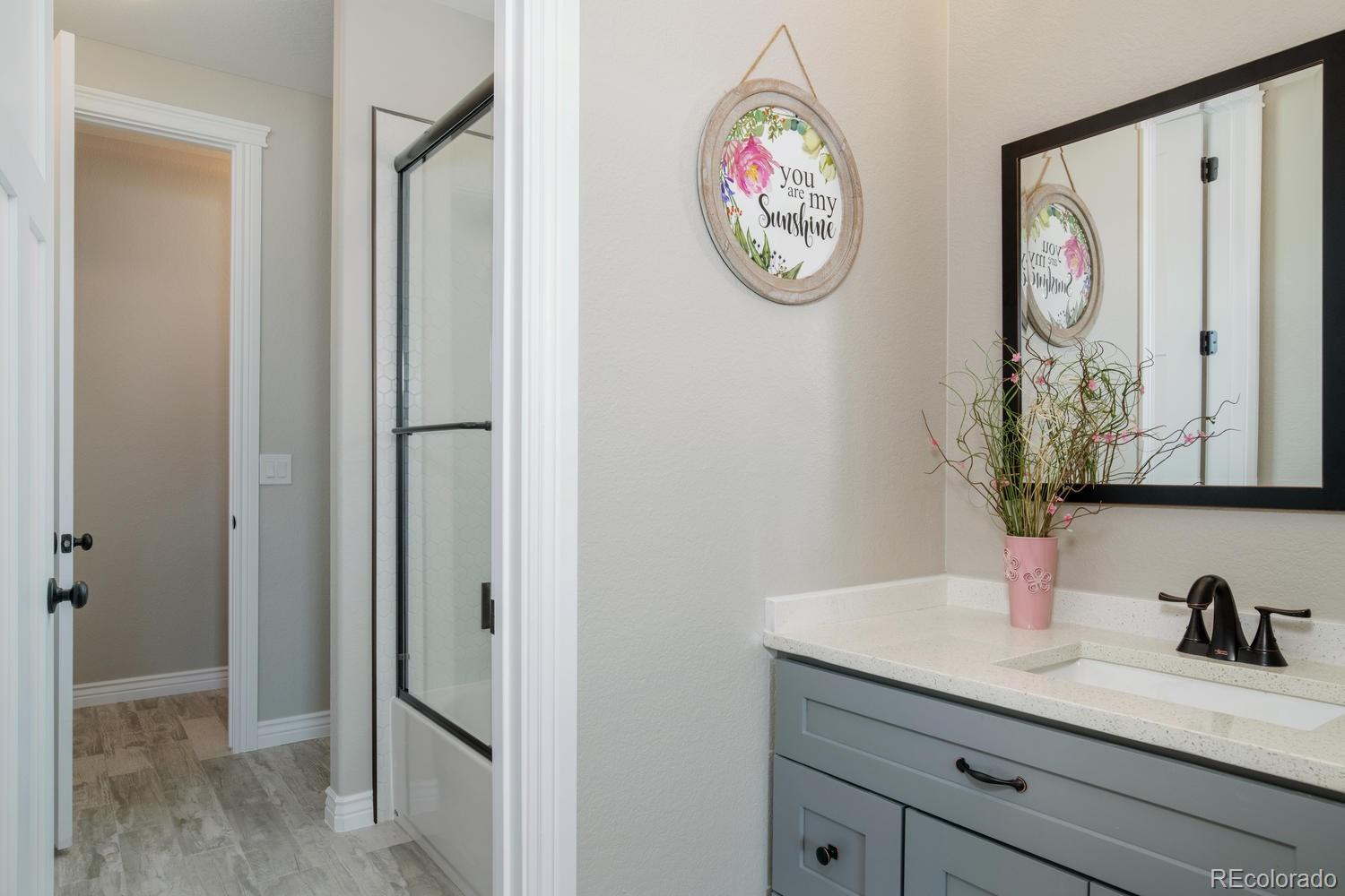 1726 Virginia Drive Fort Lupton, CO 80621 - Photo 21 of 36 a bathroom with a granite countertop sink and a mirror