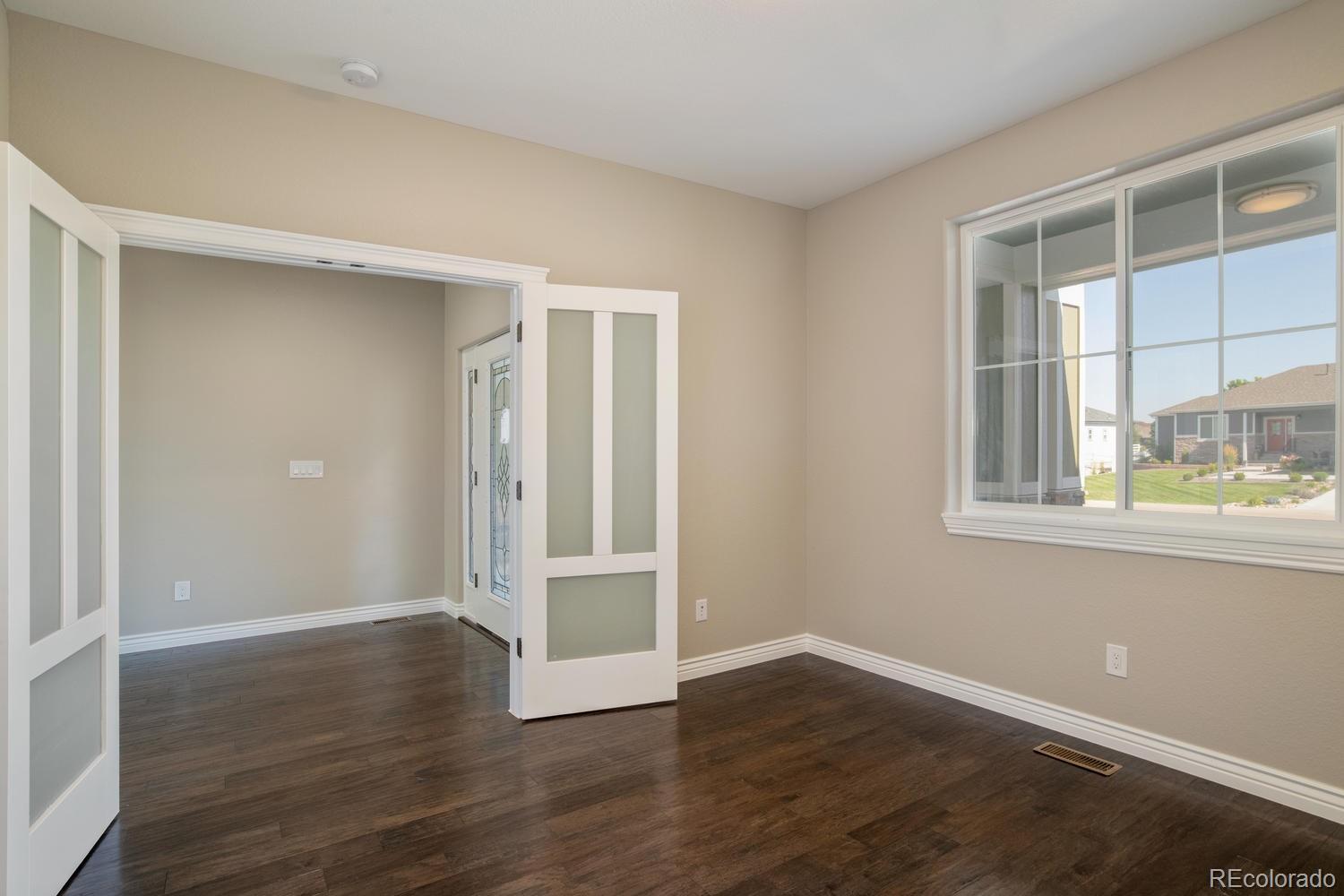 1726 Virginia Drive Fort Lupton, CO 80621 - Photo 3 of 36 a view of an empty room with wooden floor and windows