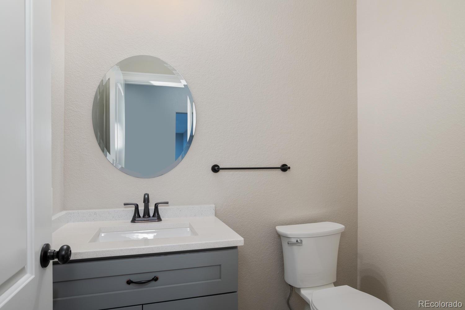 1726 Virginia Drive Fort Lupton, CO 80621 - Photo 34 of 36 a bathroom with a toilet a sink and mirror