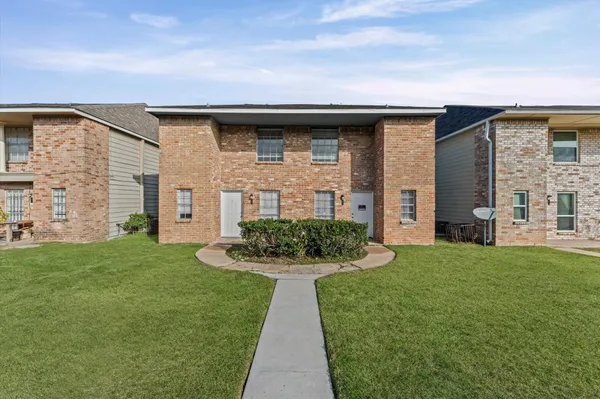 a front view of a house with a garden and plants
