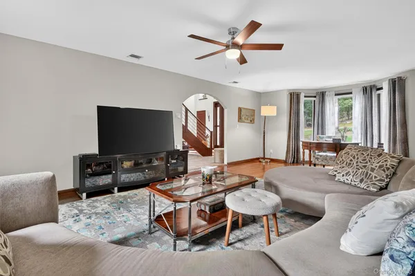 a living room with furniture a rug and a flat screen tv