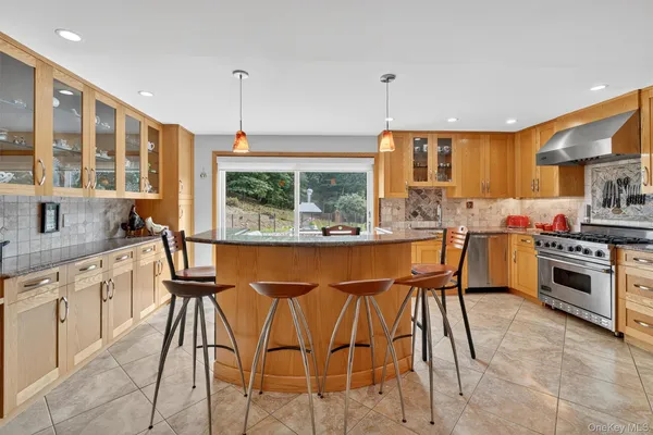 a kitchen with stainless steel appliances granite countertop a stove a sink dishwasher and a refrigerator with wooden floor