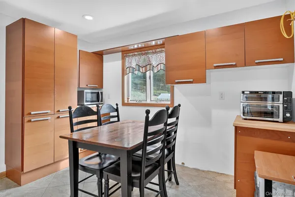a bathroom with a granite countertop sink a toilet a mirror and shower