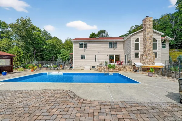 a view of a house with pool and sitting area