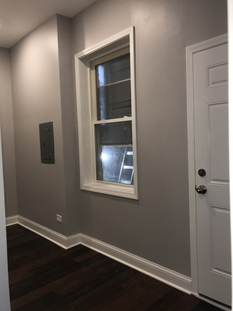 2734 West 18th Street, Unit 1F Chicago, IL 60608 - Photo 6 of 14 a view of an empty room with wooden floor and a window