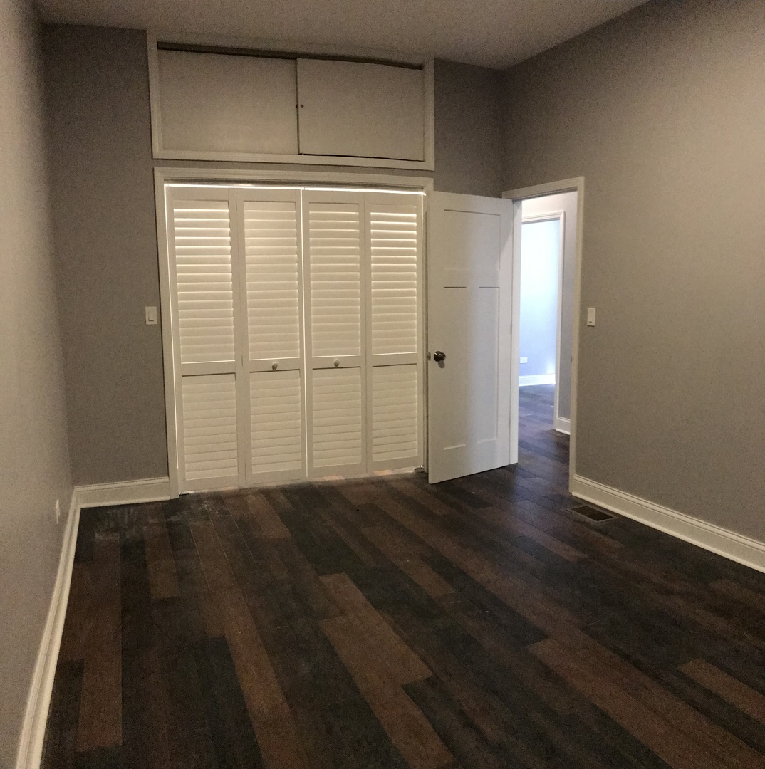 2734 West 18th Street, Unit 1F Chicago, IL 60608 - Photo 10 of 14 an empty room with wooden floor and cabinet