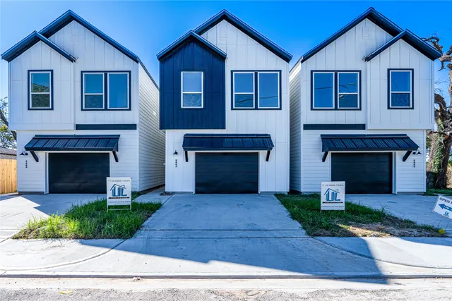 a front view of a house with yard and parking