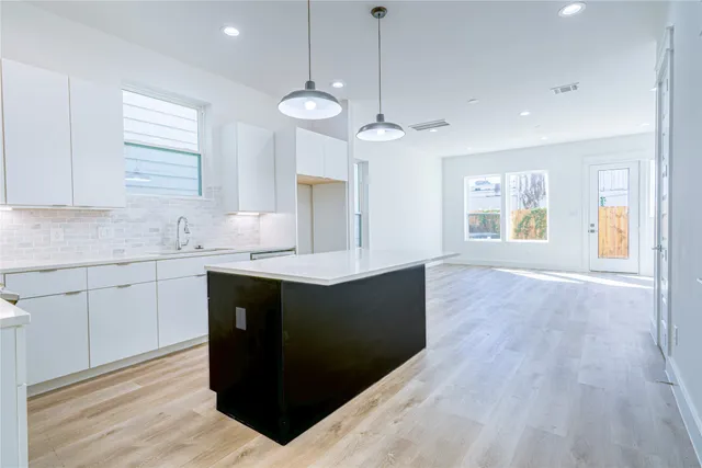 a kitchen with granite countertop a sink cabinets and window