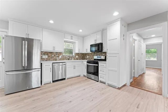 a kitchen with a refrigerator a stove top oven and kitchen island