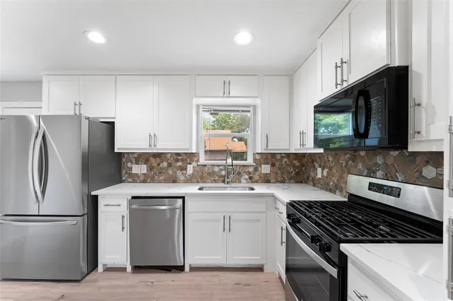 a kitchen with a stove a sink and a refrigerator