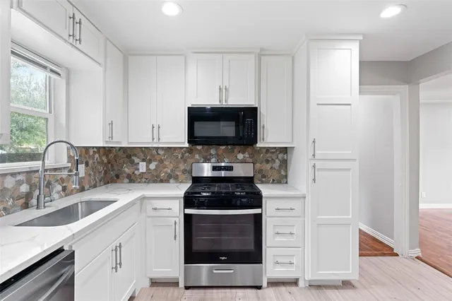 a kitchen with white cabinets and a stove top oven
