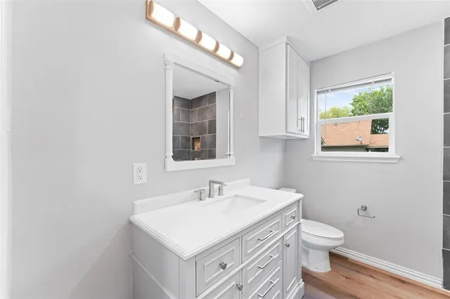 a bathroom with a sink toilet and a window