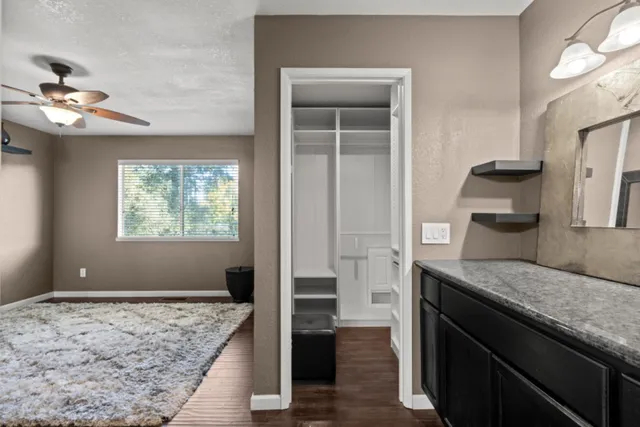 a kitchen with kitchen island a counter top space appliances and a ceiling fan