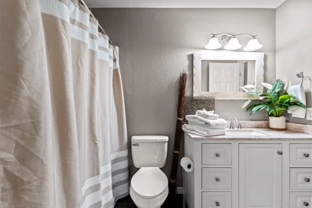 a bathroom with a toilet a sink and a mirror