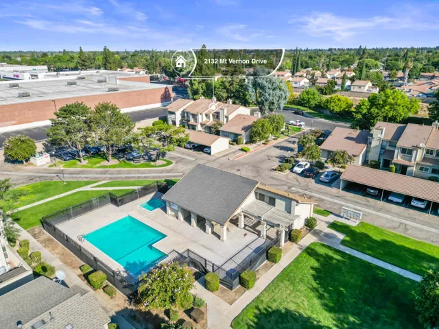 an aerial view of a house with a garden and lake view