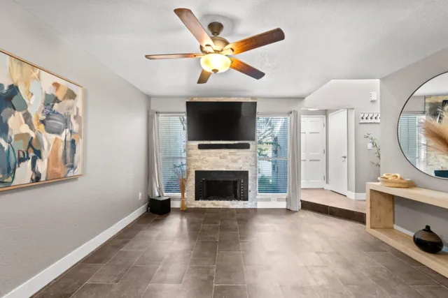 a living room with furniture a flat screen tv and a fireplace