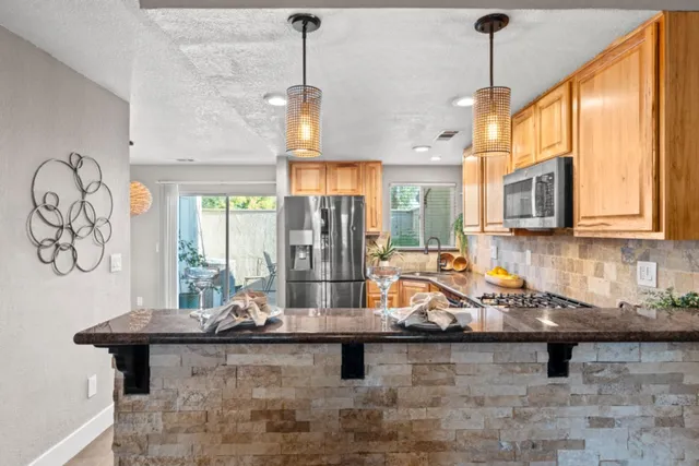 a kitchen with a sink a stove and a wooden floor
