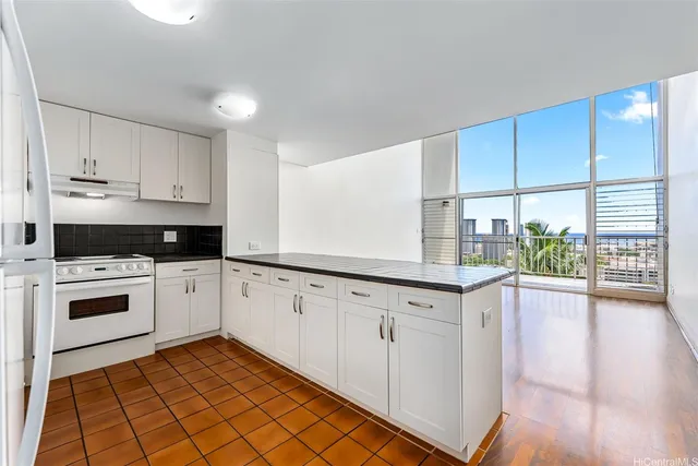 a kitchen with granite countertop white cabinets and white appliances