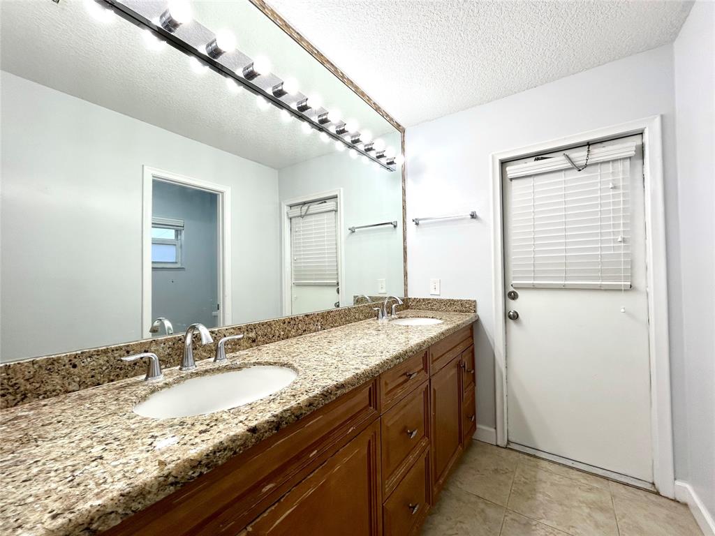 8948 Southwest 18th Road Boca Raton, FL 33433 - Photo 22 of 24 a bathroom with a granite countertop sink and a mirror