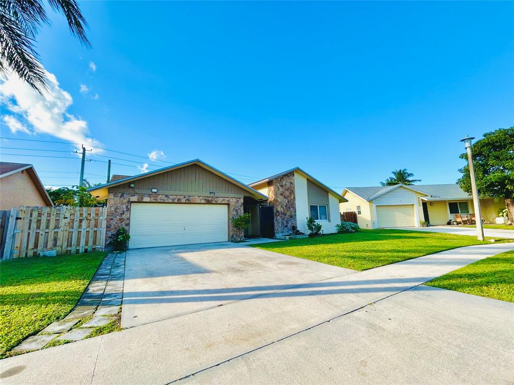 8948 Southwest 18th Road Boca Raton, FL 33433 - Photo 4 of 24 a front view of a house with a yard and garage