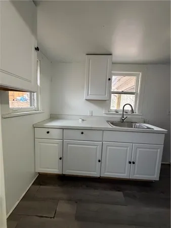 a kitchen with granite countertop white cabinets and a sink