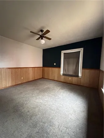 a view of an empty room and a ceiling fan