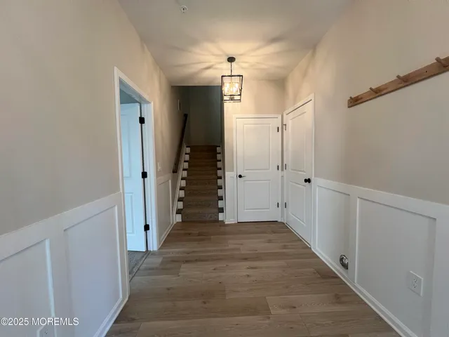 a view of a hallway with a chandelier fan and closet