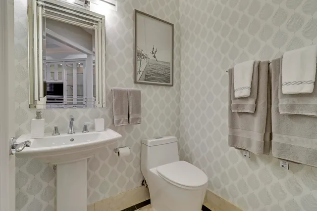 a bathroom with a toilet a sink and a mirror